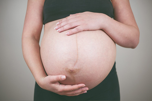 Barriga de grávida com uma linha negra