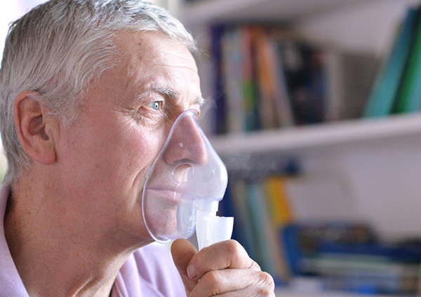 Homem com dispneia a utilizar máscara de oxigénio