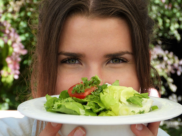 Mulher a segurar prato com salada