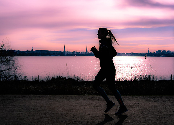 Mulher a fazer jogging junto a lago