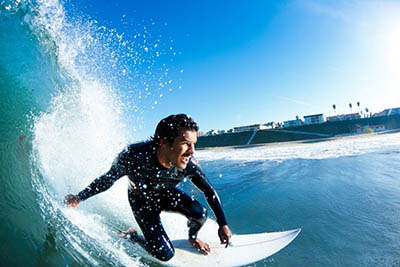 Homem a fazer surf para ilustrar as exostoses ou ouvido de surfista