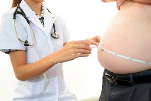 Médica a medir barriga de homem obeso