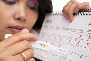 Mulher com teste de gravidez e calendário