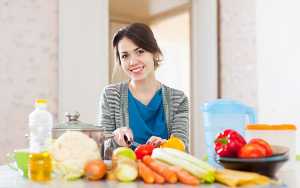 Mulher na cozinha com vários alimentos