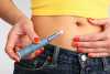 Mulher a aplicar injeção de insulina na barriga