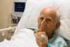 Homem deitado em cama de hospital