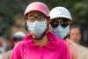Duas mulheres asiáticas com máscara cirúrgica na rua