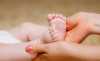 Mãos a segurar os pés de recém nascido